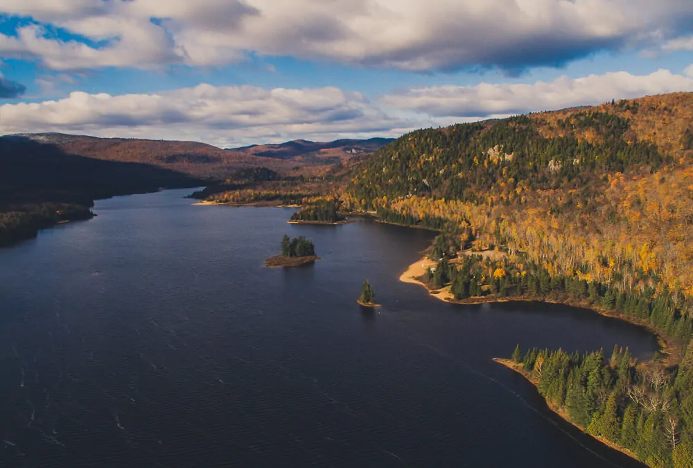 Montes Laurentides e rio com águas escuras no meio.