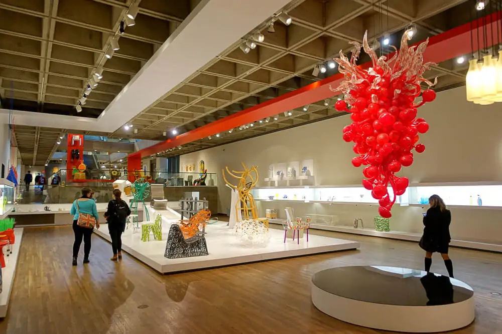 Exposições dentro do Museum of Fine Arts. Há esculturas modernas e pessoas no local.