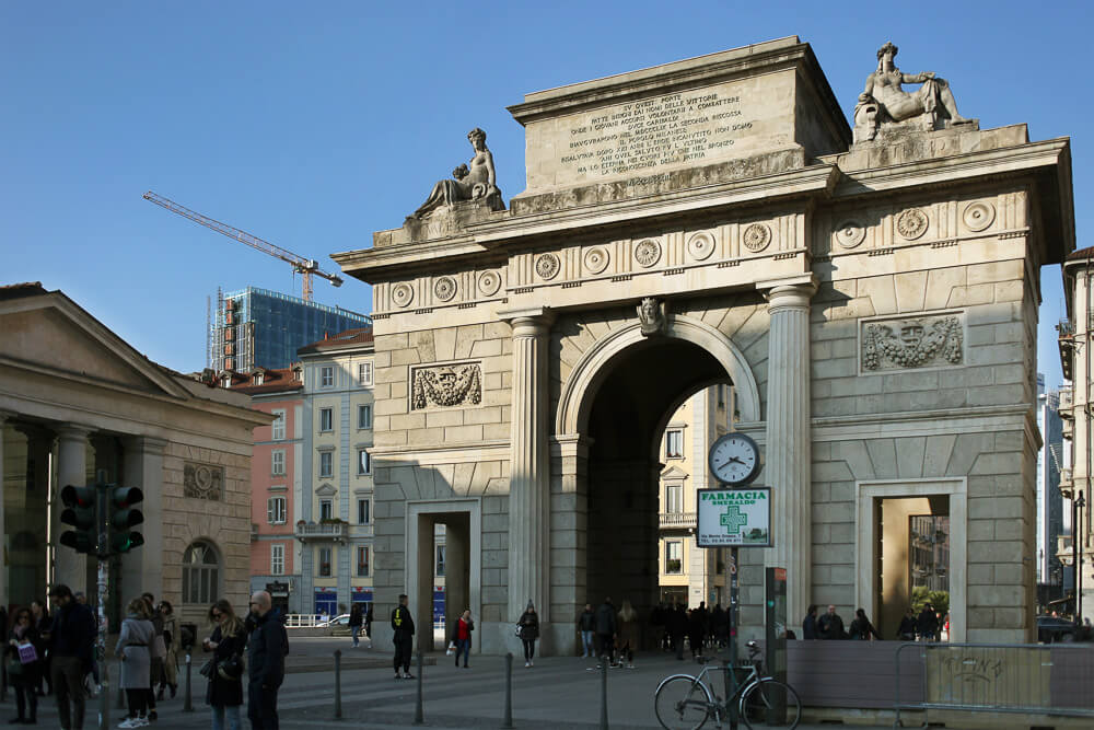 Arco na região de Porta Garibaldi. Há estátuas cinzas no topo do marco histórico.