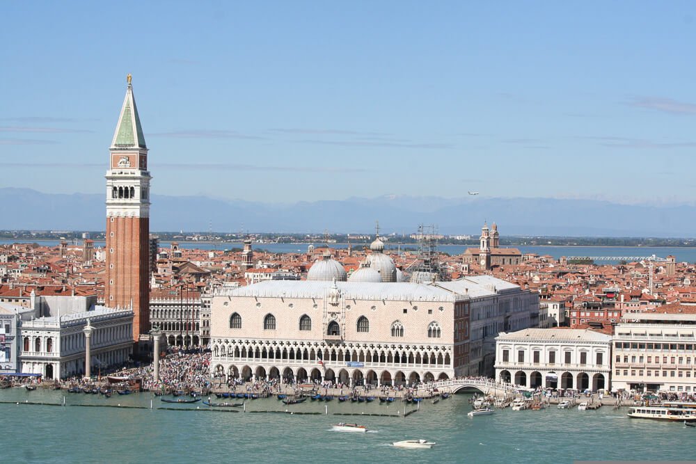 Torre vermelha com diversas construções ao redor, na Piazza San Marco
