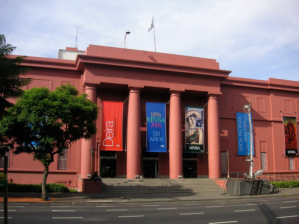 Rua asfaltada com o prédio vermelho do Museu Nacional de Belas Artes.