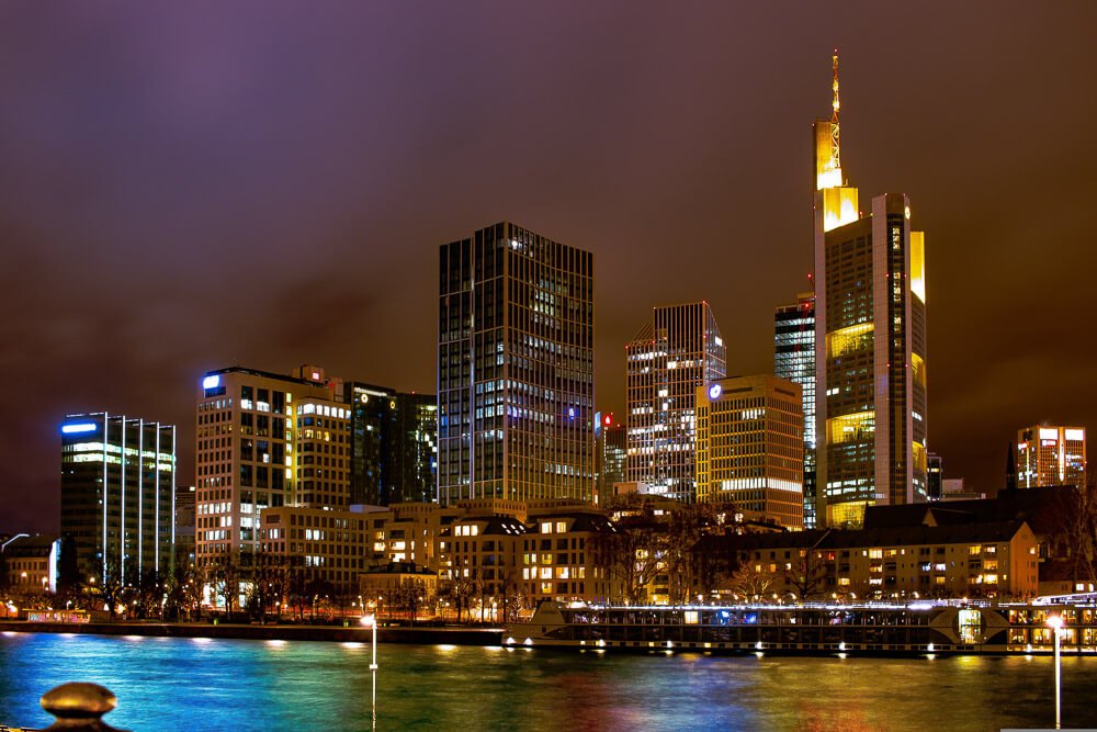 Vista noturna para o Rio Meno e para os arranha-céus luxuosos de Frankfurt.