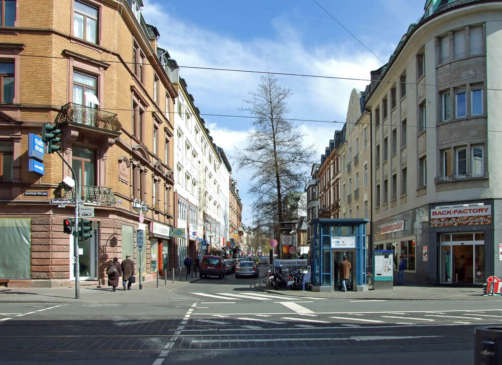 Rua Berger com edifícios em tons claros nas laterais, algumas pessoas e alguns carros.