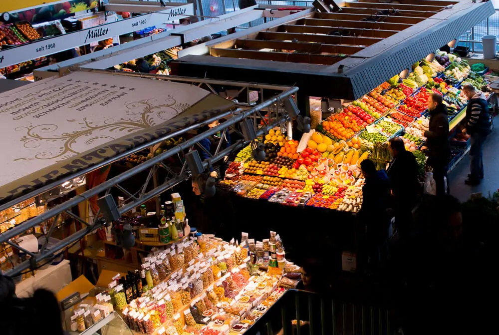 Mercado Kleinmarkthalle visto de cima, com várias frutas, legumes e verduras à venda.