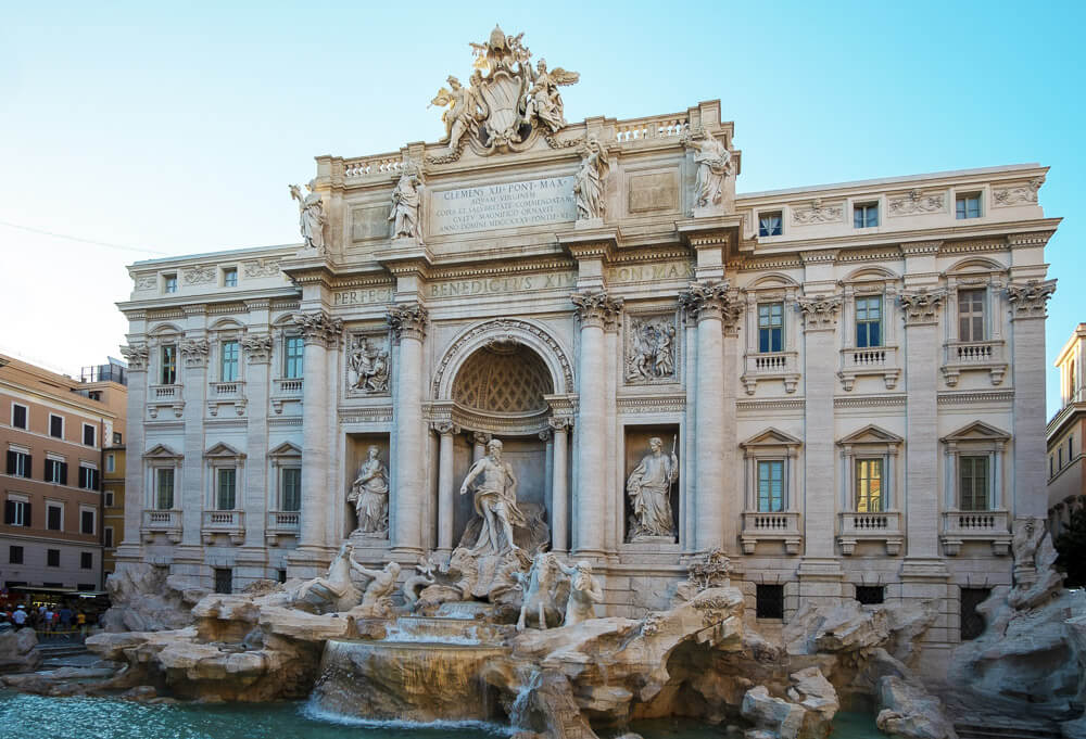 Fontana di Trevi com águas azuis-turquesa e várias estátuas em mármore.