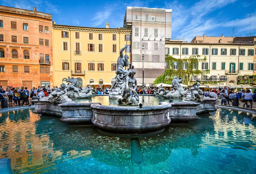 Neptune Fountain, na região norte da Piazza Navona, com vários prédios pitorescos ao redor.