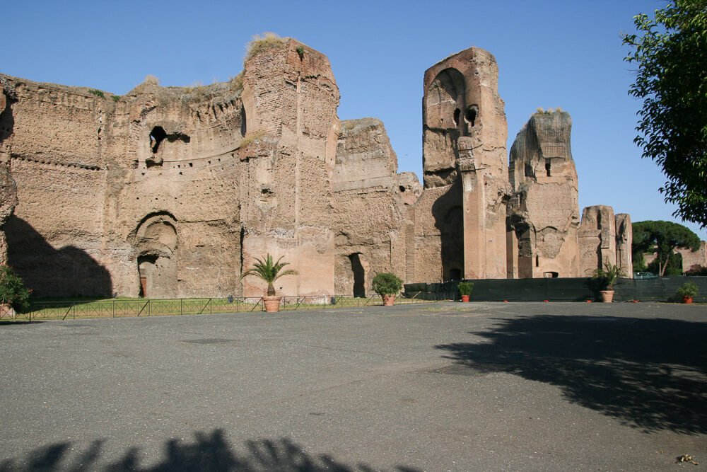 Termas de Caracalla com grandes construções de pedras amarronzadas.