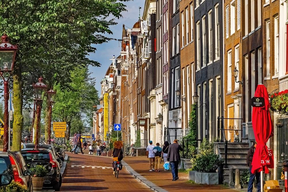 Rua estreita e calçada repleta de prédios tradicionais, na região de Jordaan.