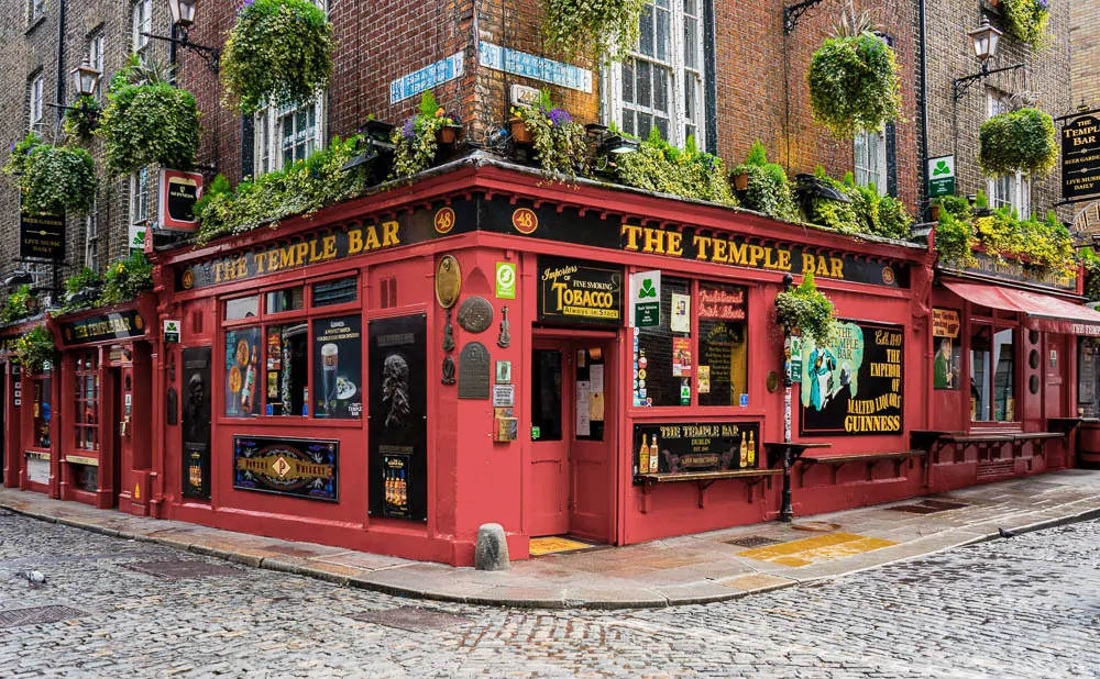Fachada do famoso The Temple Bar com paredes vermelhas e plantas decorativas.
