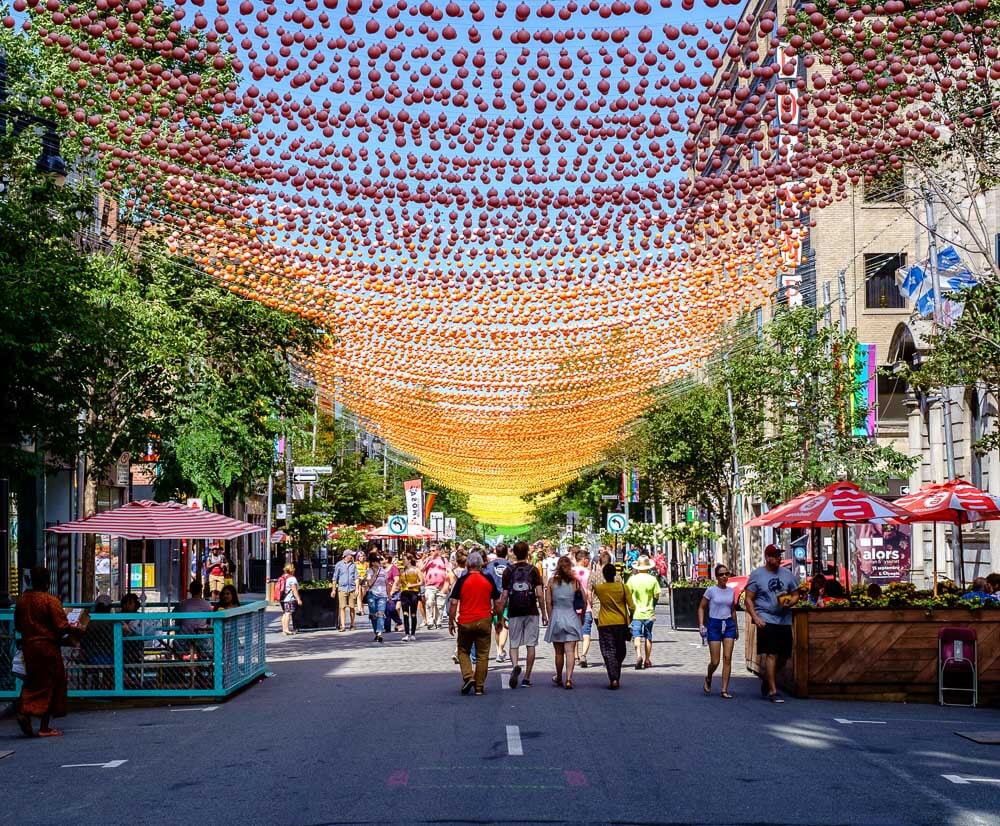 Calçadão da Rua Sainte-Catherine com várias pessoas caminhando.