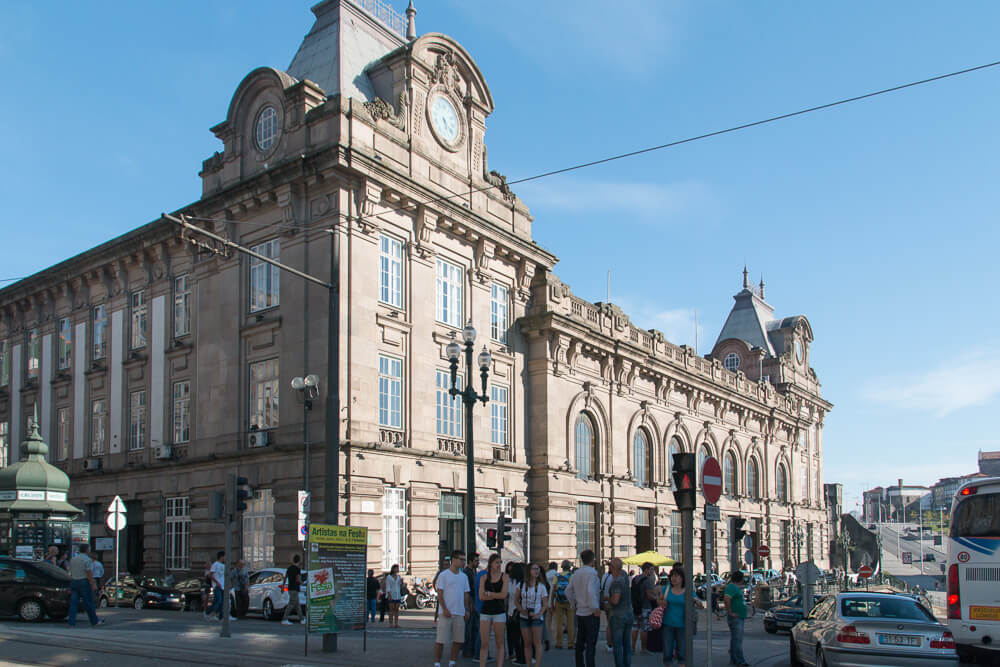 Rua movimentada com Estação de São Bento, no Centro de Porto.