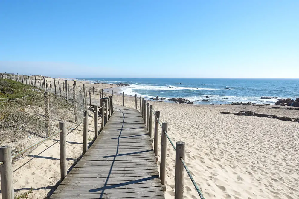 Ponte de madeira sobre areia clara da Praia da Madalena, na região de Vila Nova de Gaia.