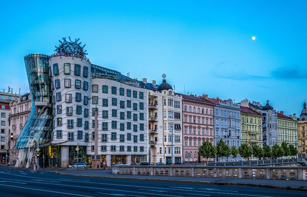 Avenida com o famoso edifício do hotel Dancing House e outro edifícios coloridos.