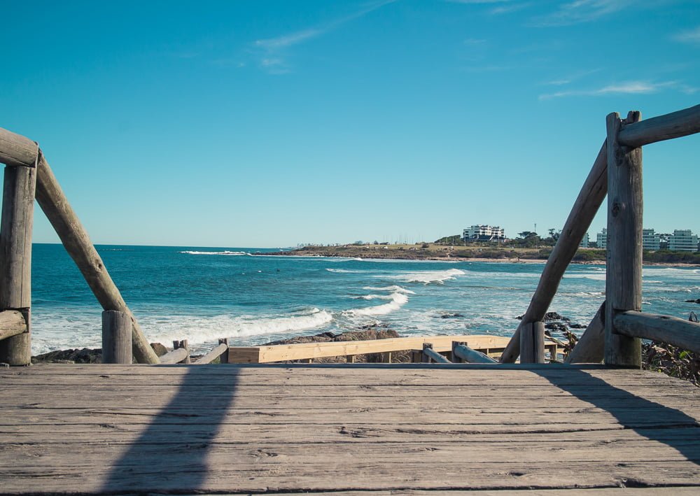 Ponte sobre a areia em uma das praias de La Barra. Ao fundo, está o mar com muitas ondas.