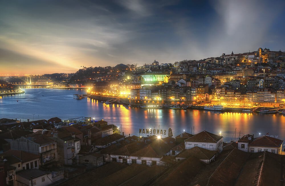 Vista noturna para as construções ao redor do Rio Douro, em Porto.