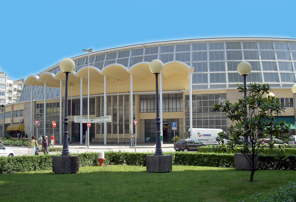 Mercado Bom Sucesso, com fachada de vidro e um gramado em frente.