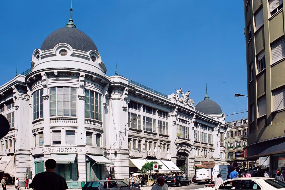 Mercado do Bolhão com muitas pessoas e automóveis ao redor.