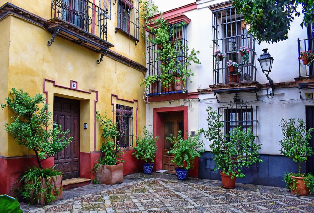 Pátio com casas coloridas e cheias de plantas, no Barrio Santa Cruz, em Sevilha.