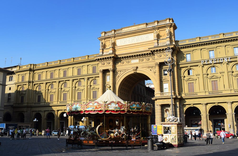Piazza della Repubblica com arco grande e um carrossel antigo.