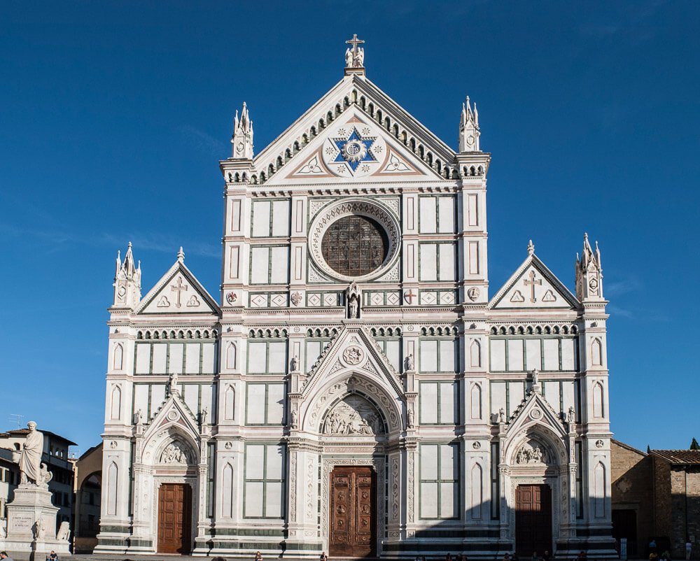 Fachada da Basílica de Santa Croce com paredes claras e topo triangular.