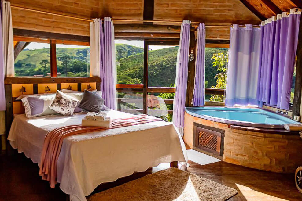 Chalé com cama espaçosa, banheira e vista para a serra da mantiqueira.
