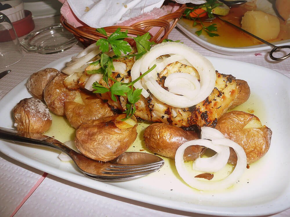 Prato com Bacalhau assado e cebolas cortadas em rodelas.