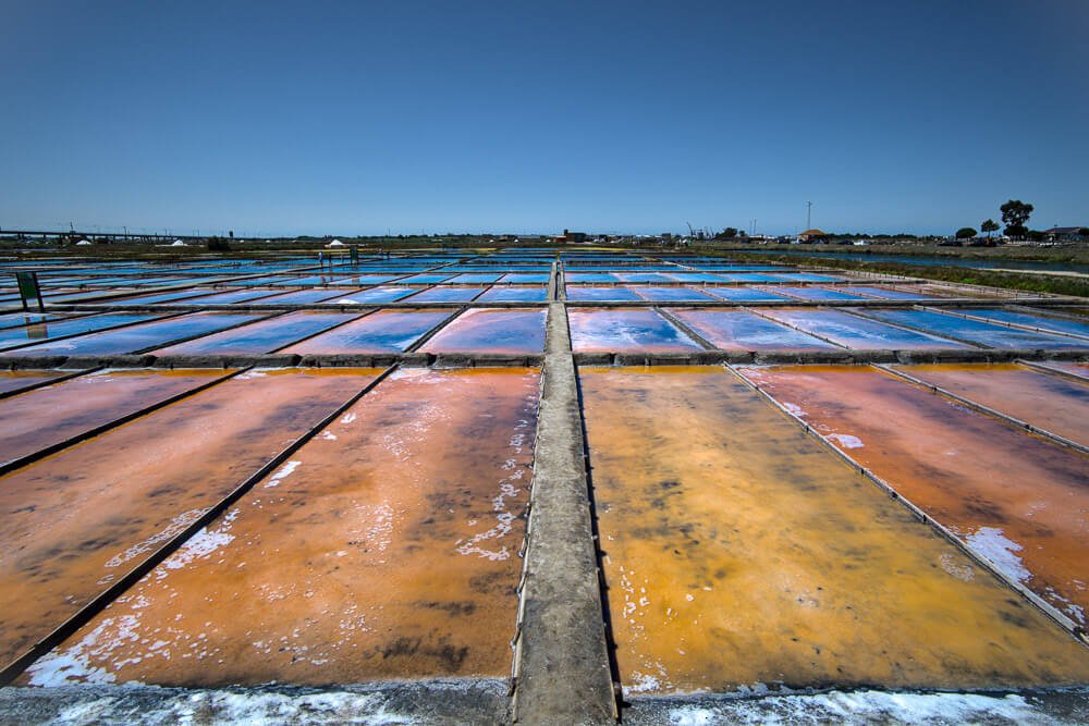 Salinas de Aveiro, com placas coloridas e céu azul ao fundo.