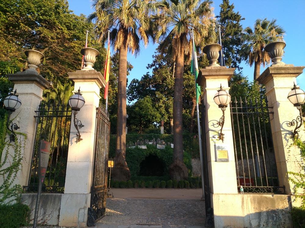 Portão de entrada do Carmen de los Mártires com muitas árvores do lado de dentro.