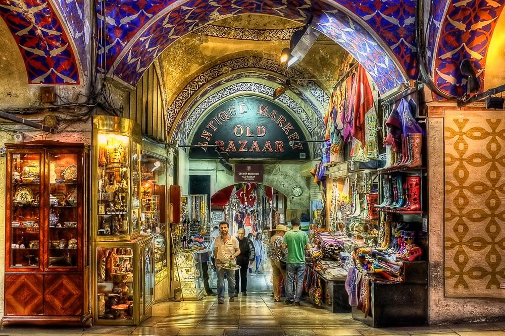 Interior do Grand Bazaar, com estrutura colorida e várias vestimentas à venda.
