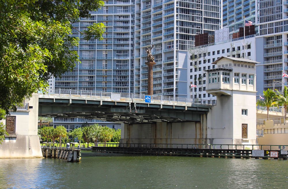 Brickell Avenue Bridge sobre o Rio Miami, com vários edifícios ao fundo.