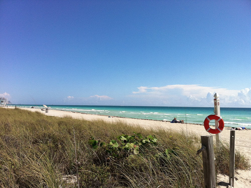 Surfside Beach, com areia clara, mar de águas cristalinas e quase nenhum banhista.