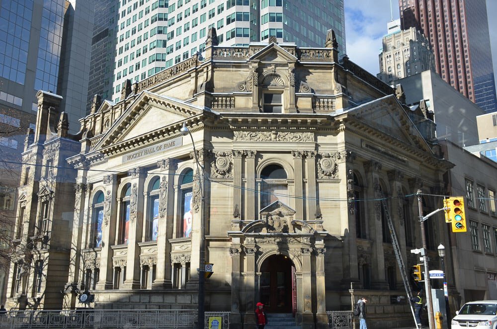 Fachada do Museu Hockey Hall of Fame com paredes em tons de areia e com arcos.