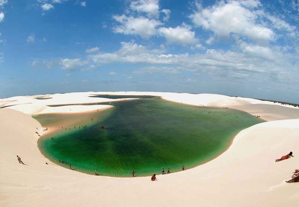 Lagoa da Gaivota, em Santo Amaro, com águas verdes, rodeada de areia e vários banhistas.