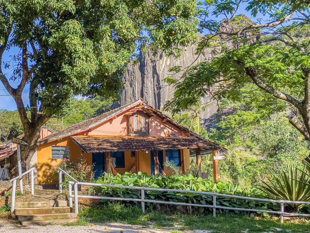 Fachada da Pousada Grande Pedreira, com paredes laranjas e com muita