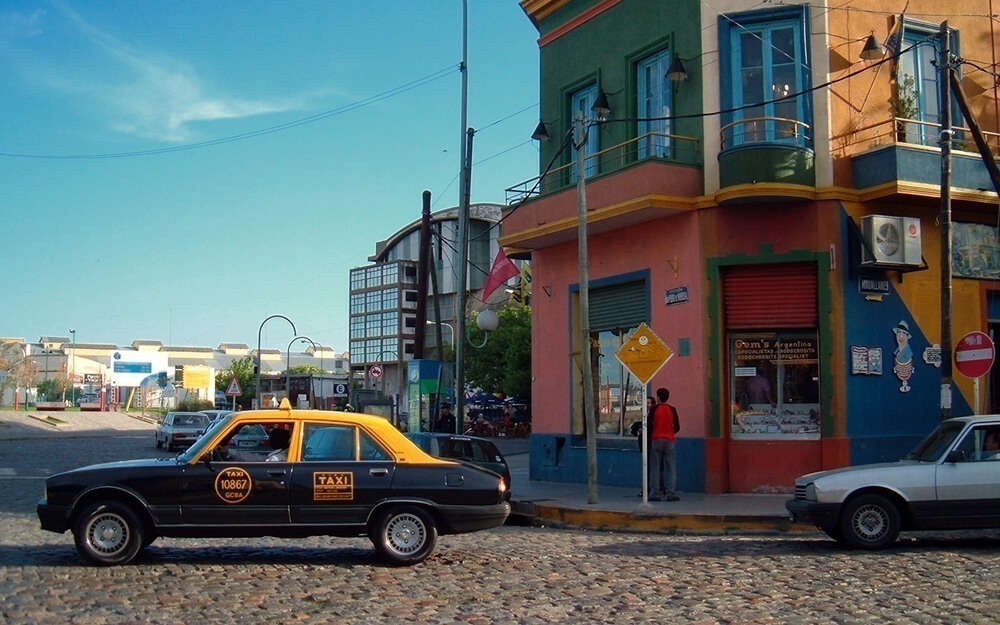 Um táxi amarelo e preto no bairro La Boca, em Buenos Aires, durante o dia.