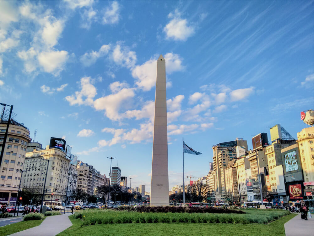 Vista de baixo para cima do Obelisco de Buenos aires, durante o dia.
