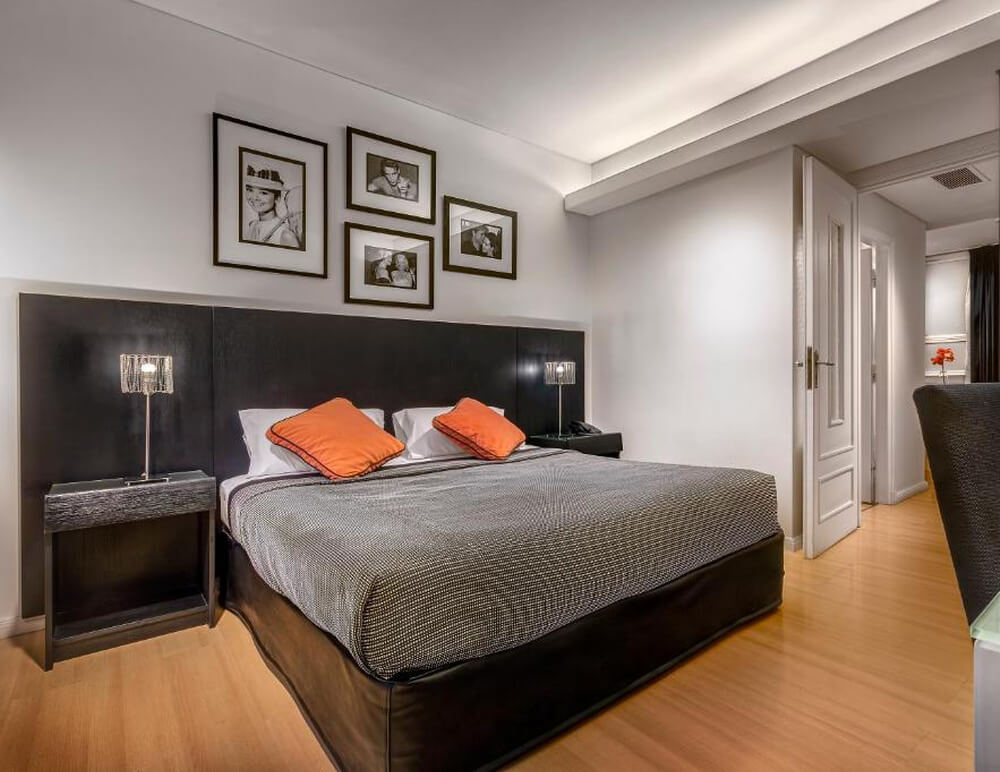 Quarto do hotel Broadway Hotel & Suites, com cama de casal e decoração sofisticada.
