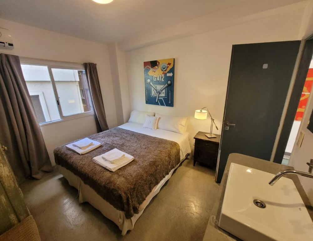 Quarto do Hotel Costa Rica, com cama de casal e área de lavabo.