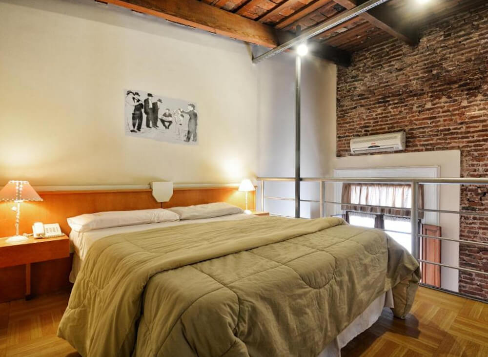 Quarto do hotel La Fresque Hotel, com cama de casal, aparelho de ar-condicionado, janela e quadro na parede.