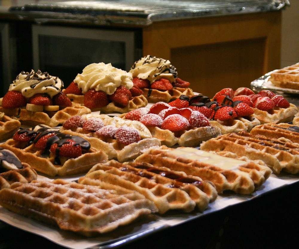 Tradicionais waffles belgas, servidos com coberturas doces e morangos frescos.