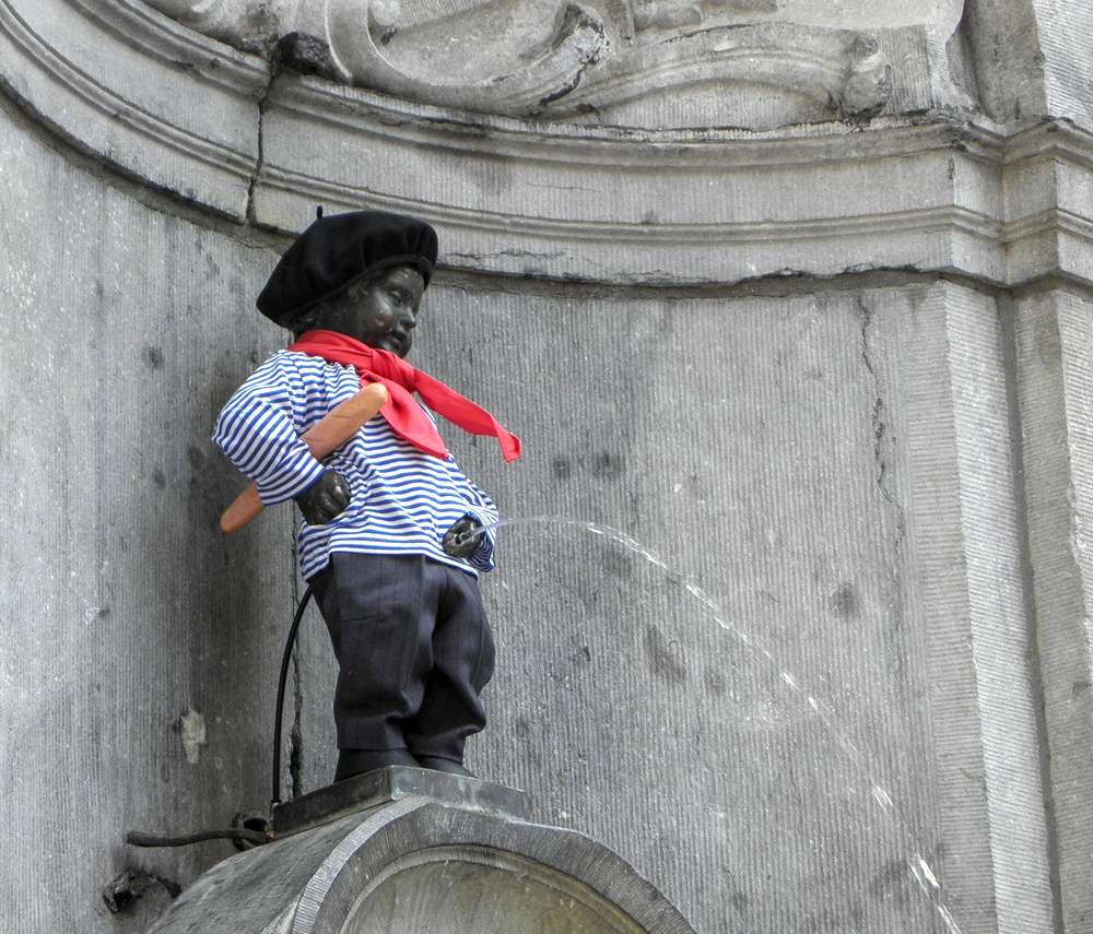 A famosa estátua Mannekin Pis em Bruxelas, com roupas e acessórios característicamente franceses.