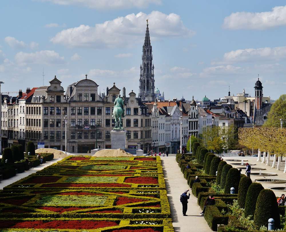 Vista dos jardins do Mont des Arts, e do Hotel de Ville no horizonte, em Bruxelas, durante o dia.