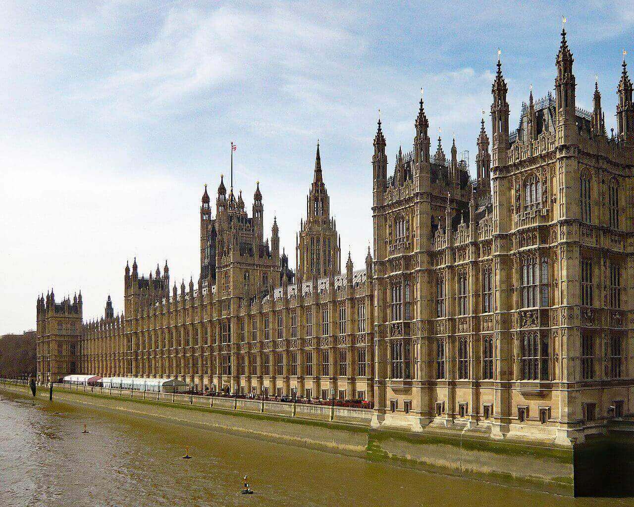 O Palácio de Westminster, a sede do Parlamento Britânico, às margens do Rio Tâmisa, em Londres, durante o dia.