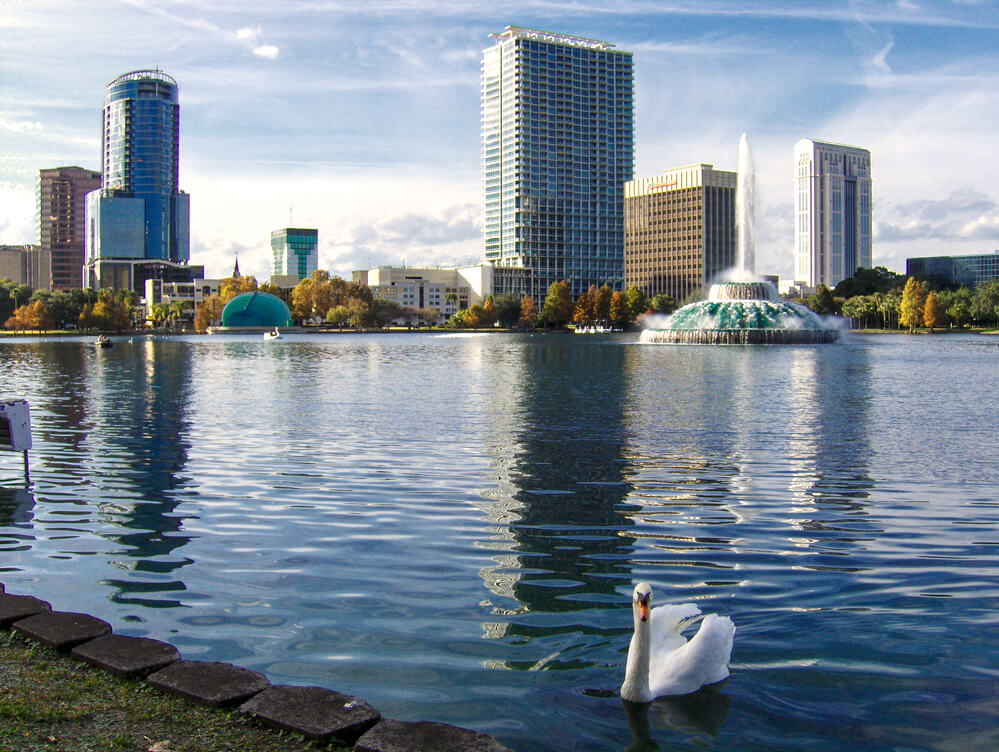 Vista do lago do Lake Eola Park e da cidade de Orlando durante o dia.
