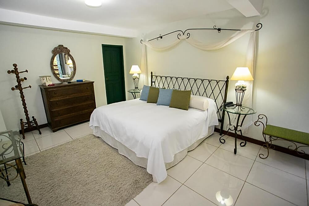 Quarto do hotel Bomtempo II Chales by Castelo Itaipava, com cama de casal e móveis de madeira.