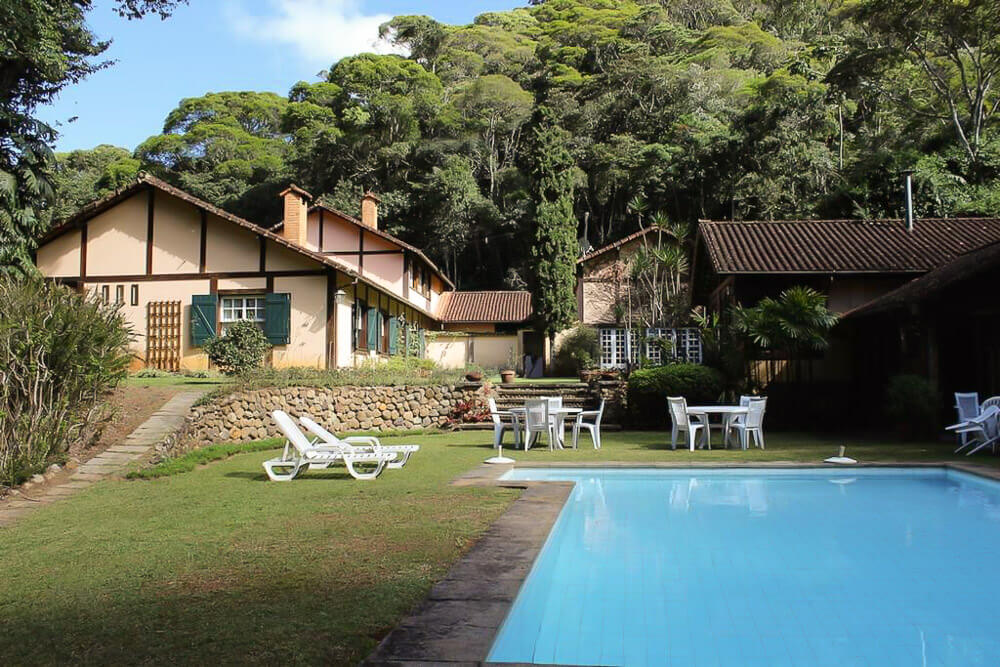 Área externa da pousada Casa do Fachoalto, com piscina e fachada dos chalés.