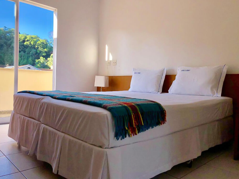 Quarto do Dom Pedro hotel, com cama de casal e varanda.