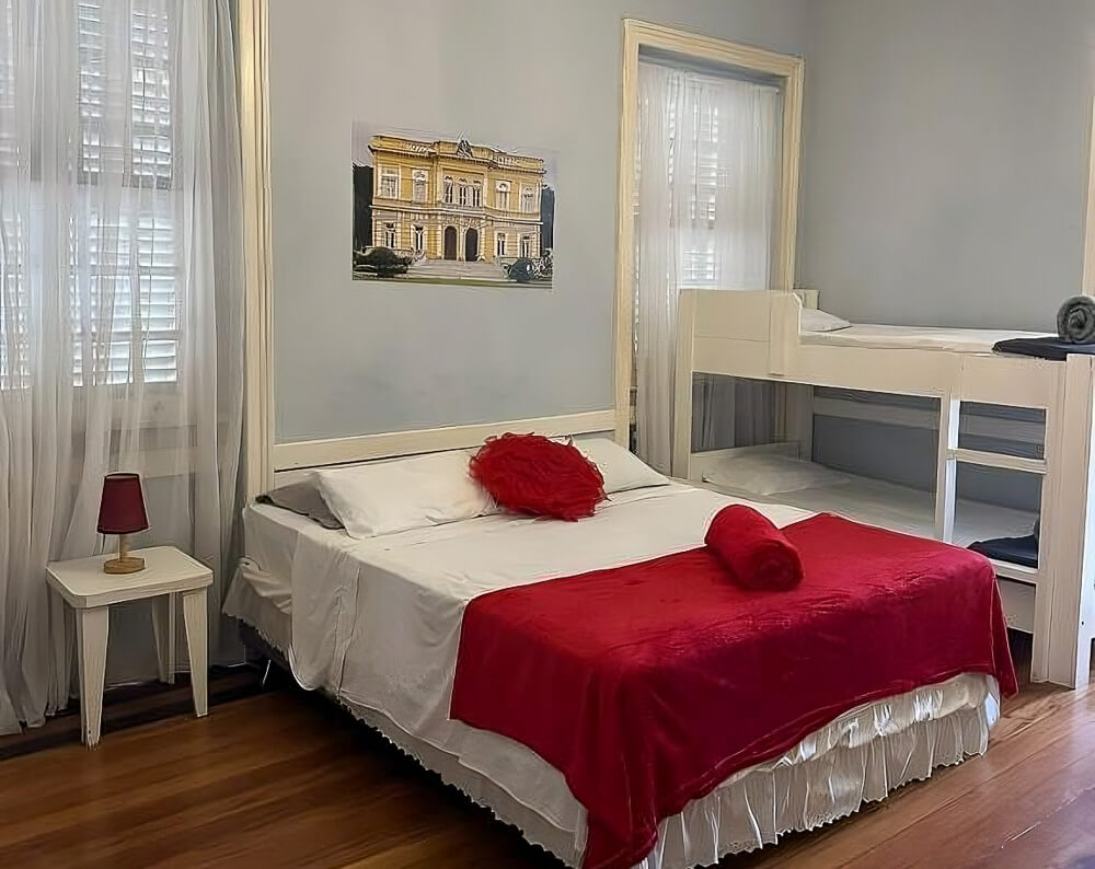 Quarto do hotel Cidade Imperial, com cama de casal e beliche.