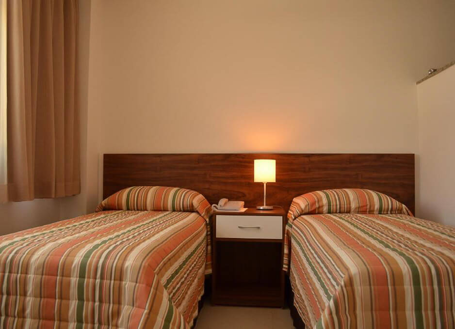 Quarto do Hotel Flat Itaipava, com duas camas de solteiro.