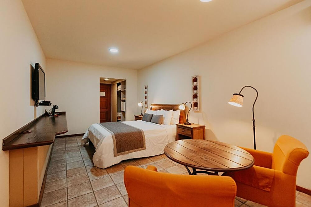 Quarto do hotel Kastel Itaipava, com decoração laranja.